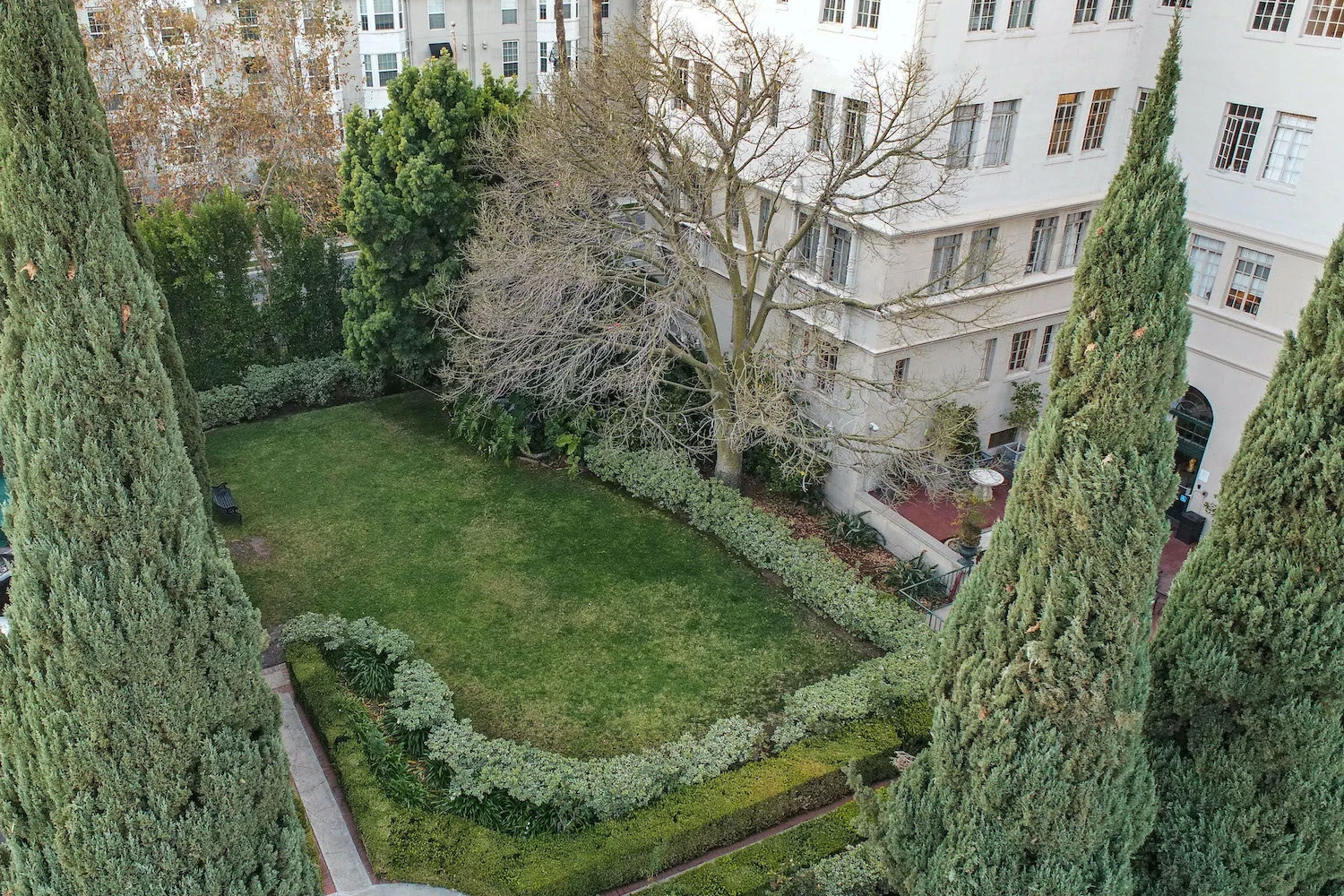El Royale — manicured private courtyard garden with cypress trees